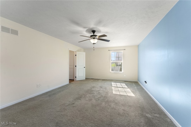 spare room featuring a textured ceiling, light colored carpet, and ceiling fan