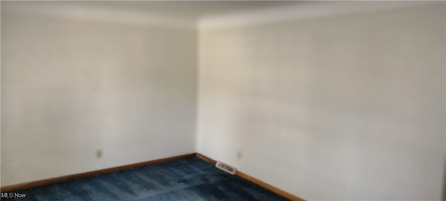 empty room with dark colored carpet