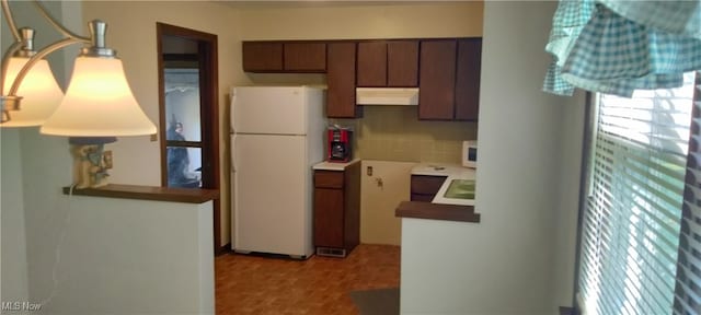 kitchen with backsplash, dark brown cabinetry, plenty of natural light, and white appliances