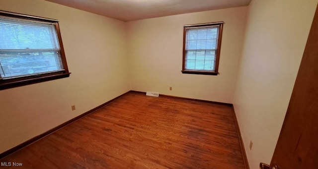 empty room with plenty of natural light and wood-type flooring