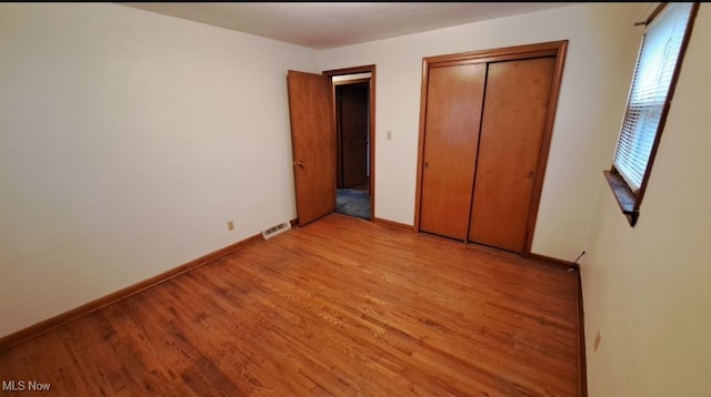 unfurnished bedroom with a closet and light hardwood / wood-style floors