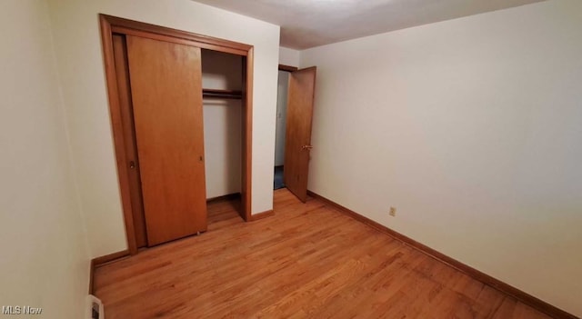 unfurnished bedroom with light hardwood / wood-style floors and a closet