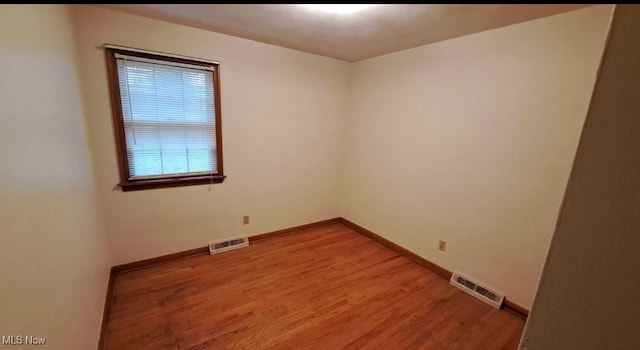 spare room featuring wood-type flooring