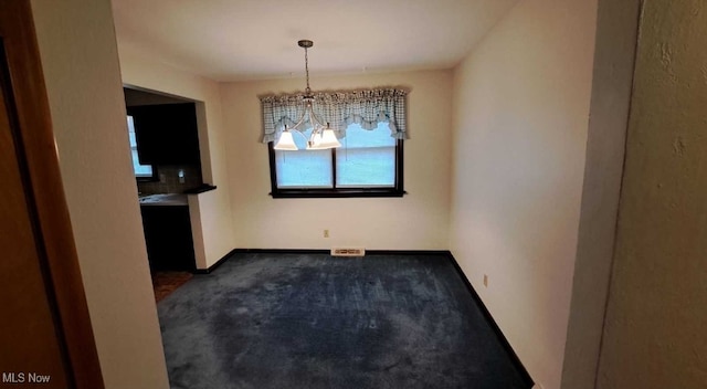 unfurnished dining area featuring carpet and a notable chandelier