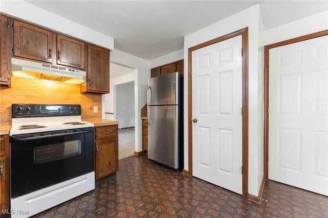 kitchen featuring stainless steel fridge, electric range, and tasteful backsplash