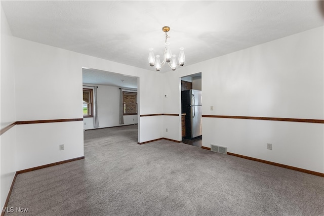 empty room with a chandelier and carpet floors