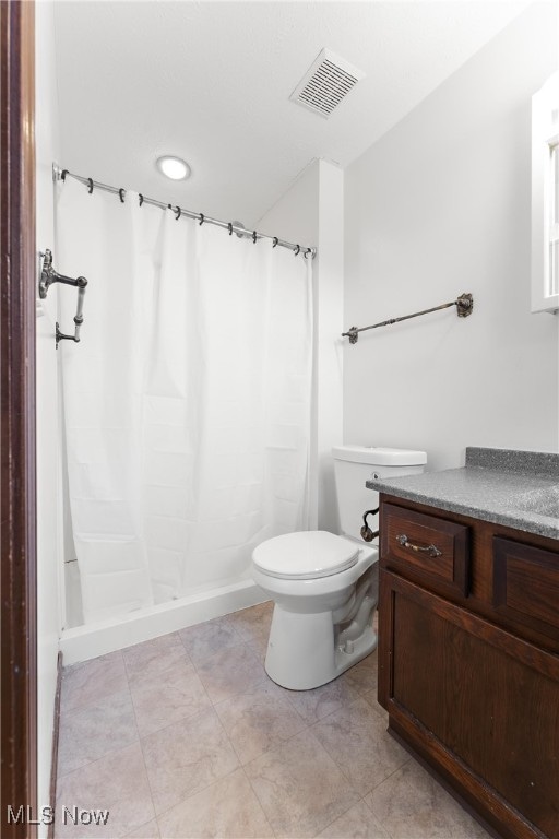 bathroom featuring toilet, walk in shower, and vanity