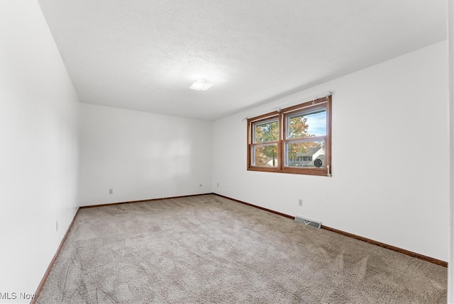 carpeted spare room with a textured ceiling