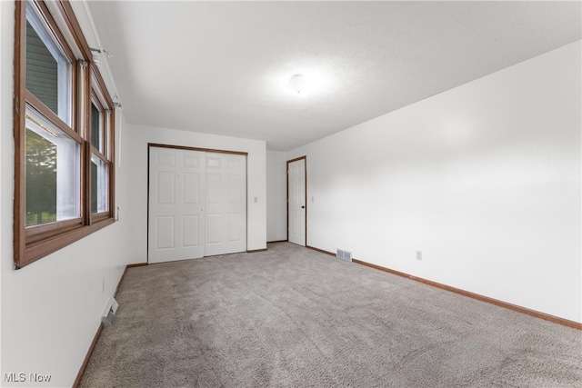 unfurnished bedroom with carpet floors and a closet