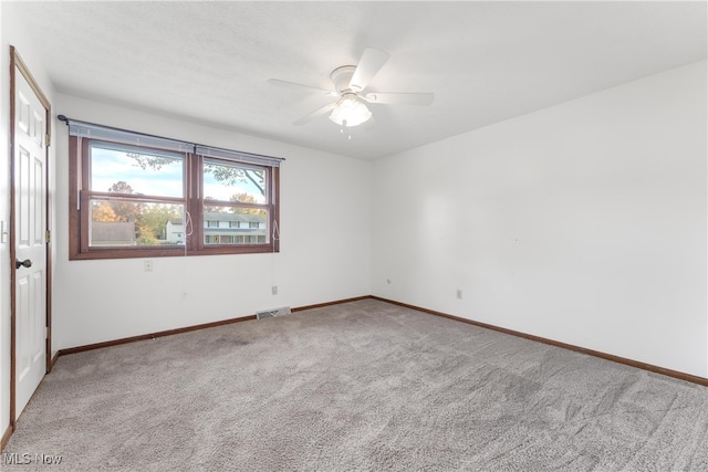 carpeted spare room with ceiling fan