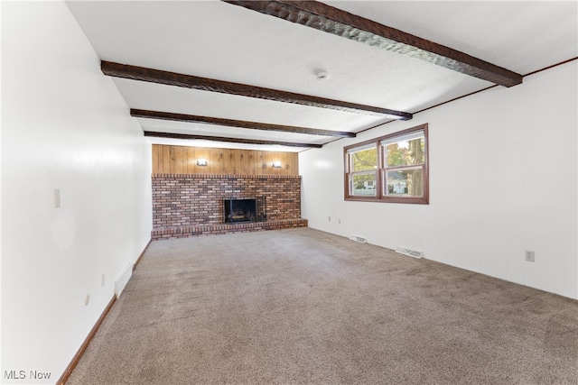 unfurnished living room featuring beam ceiling, carpet flooring, and a fireplace