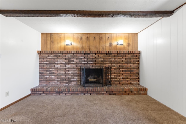 unfurnished living room with a fireplace, beamed ceiling, carpet, and wooden walls