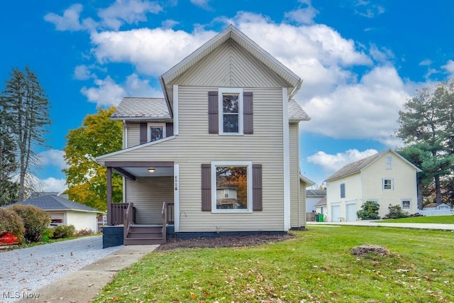 view of front property featuring a front yard, a garage, and covered porch