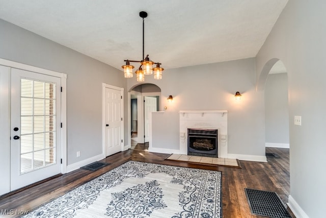 living room with a textured ceiling, an inviting chandelier, and dark hardwood / wood-style flooring