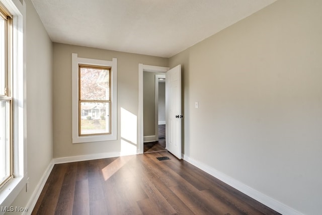 unfurnished room featuring dark hardwood / wood-style floors and a textured ceiling