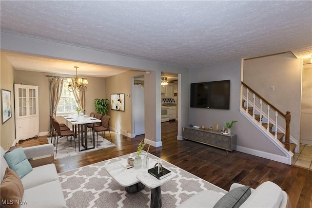 living room with a textured ceiling, dark hardwood / wood-style flooring, and an inviting chandelier