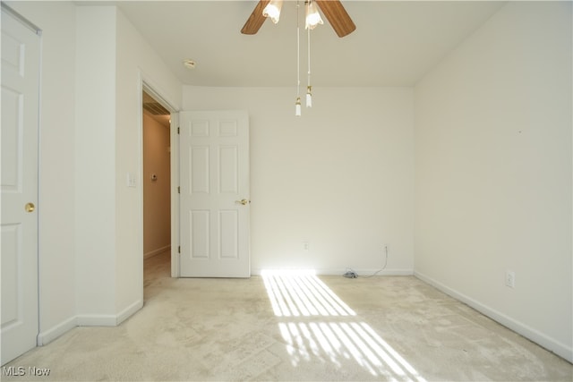 carpeted spare room with ceiling fan