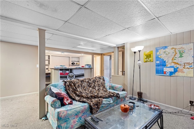 carpeted living room featuring a drop ceiling