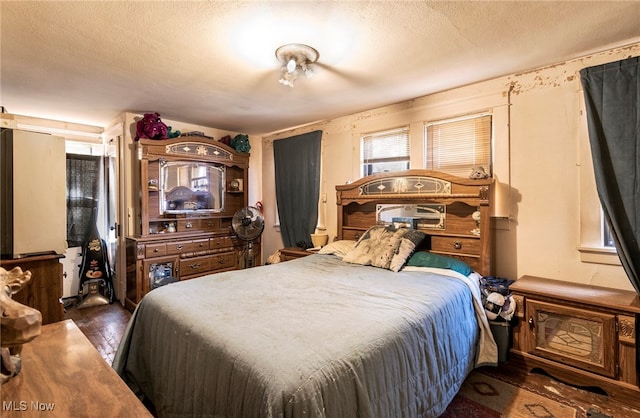 bedroom featuring a textured ceiling and dark hardwood / wood-style floors