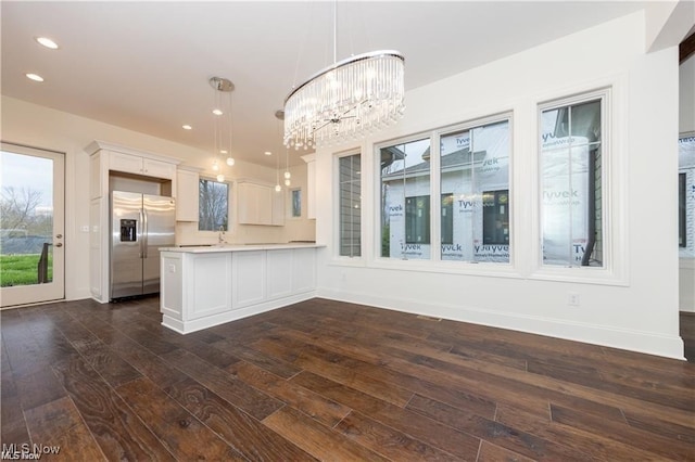 kitchen with white cabinets, hanging light fixtures, dark hardwood / wood-style flooring, and stainless steel refrigerator with ice dispenser