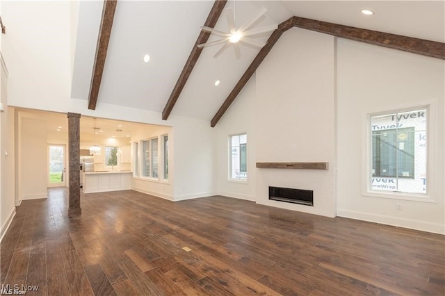 unfurnished living room featuring beamed ceiling, dark wood-type flooring, ornate columns, and high vaulted ceiling