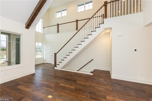 foyer with plenty of natural light, high vaulted ceiling, and dark hardwood / wood-style flooring