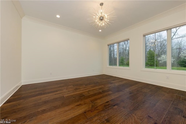 spare room featuring ornamental molding, a chandelier, and dark hardwood / wood-style floors