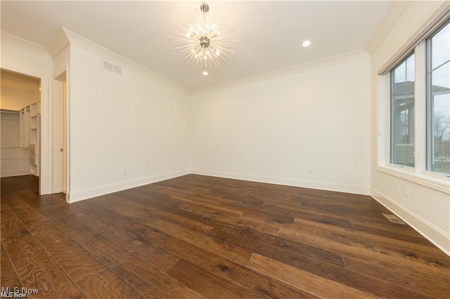 empty room with ornamental molding, a notable chandelier, and dark hardwood / wood-style flooring