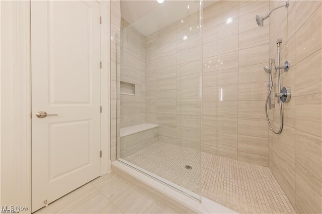 bathroom with an enclosed shower and tile patterned floors