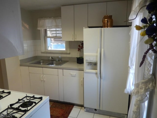 kitchen with tasteful backsplash, sink, light tile patterned floors, and white appliances