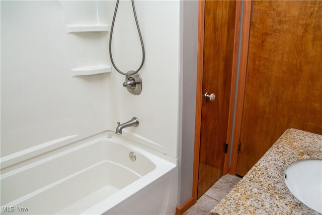 bathroom featuring tile patterned flooring, shower / bathing tub combination, and vanity