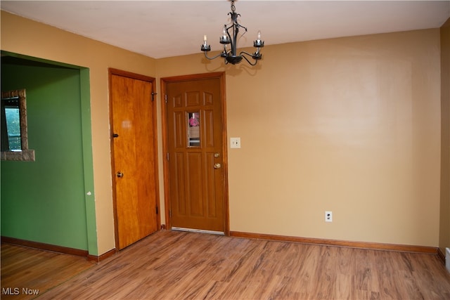 unfurnished room featuring hardwood / wood-style flooring and a chandelier