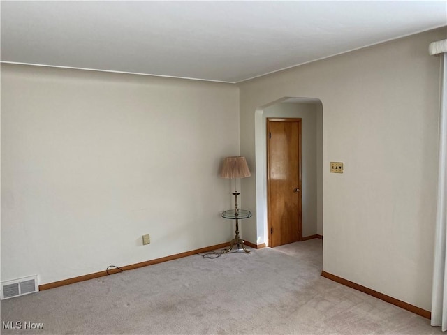 421 W Omar St, Struthers, OH 44471 - empty room with visible vents, baseboards, arched walkways, and light carpet