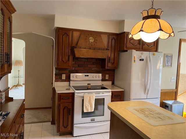 kitchen with premium range hood, backsplash, light tile patterned floors, and white appliances