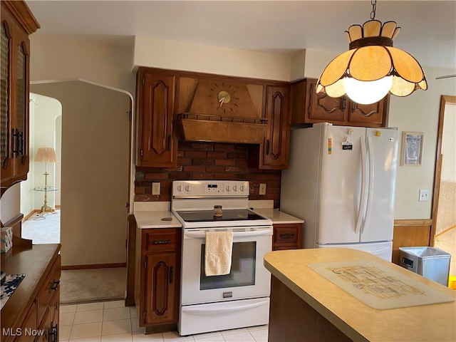 421 W Omar St, Struthers, OH 44471 - kitchen featuring white appliances, decorative light fixtures, light tile patterned flooring, light countertops, and arched walkways