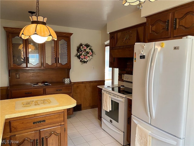 kitchen with a wealth of natural light, light tile patterned floors, hanging light fixtures, and white appliances