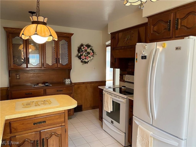 421 W Omar St, Struthers, OH 44471 - kitchen featuring white appliances, light tile patterned flooring, light countertops, wainscoting, and hanging light fixtures