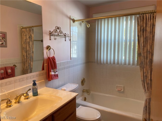 full bathroom featuring shower / tub combo, vanity, toilet, and tile walls