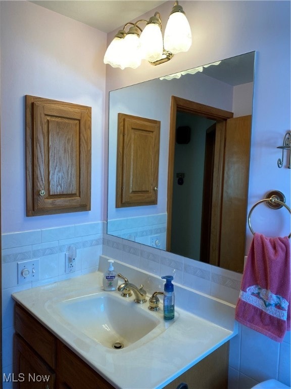 bathroom featuring vanity and tile walls