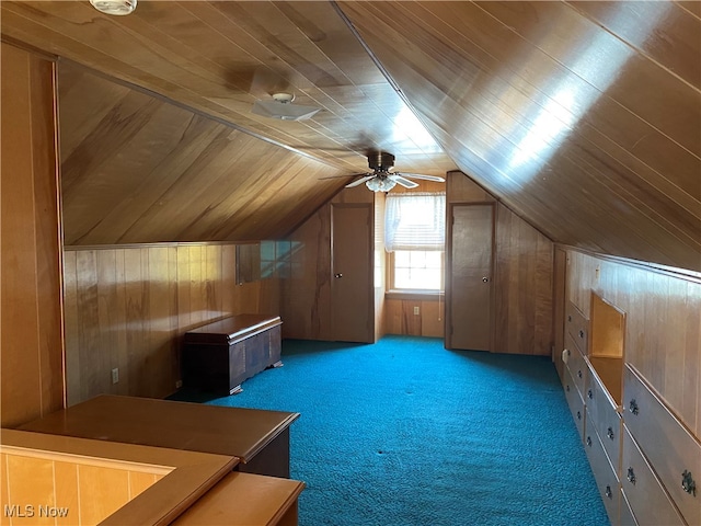 bonus room with carpet, wooden walls, ceiling fan, and lofted ceiling