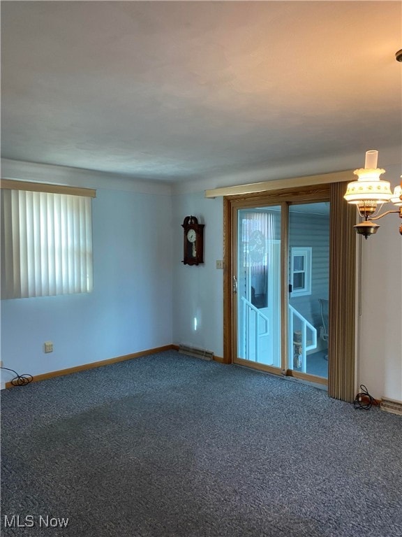 empty room with carpet and a chandelier