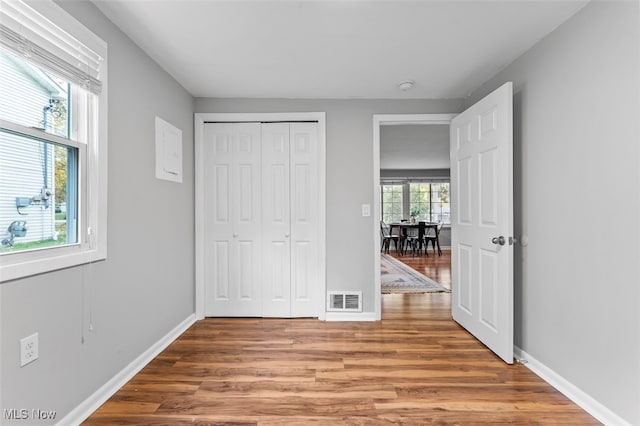 unfurnished bedroom with hardwood / wood-style floors and a closet