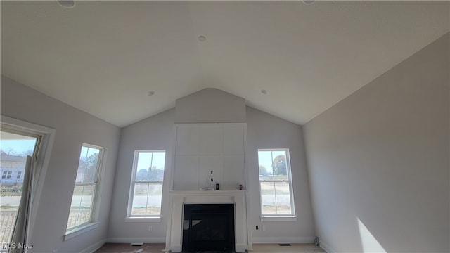 unfurnished living room with a wealth of natural light and lofted ceiling