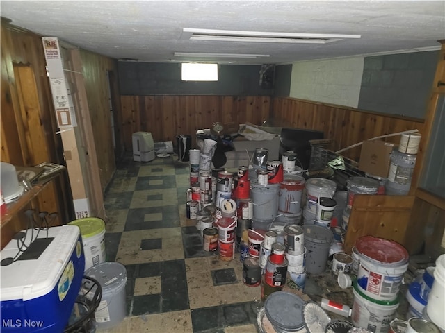 basement with wood walls and a textured ceiling