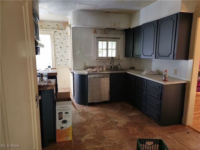 kitchen featuring decorative backsplash, dishwasher, and sink