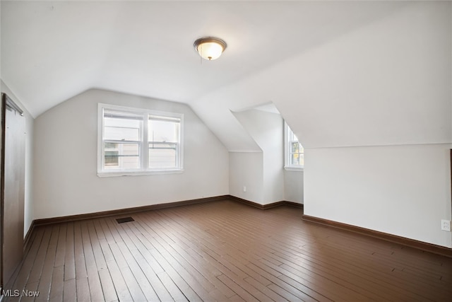 additional living space featuring lofted ceiling and dark hardwood / wood-style floors