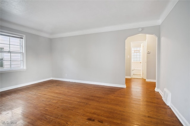 empty room with crown molding and dark hardwood / wood-style floors