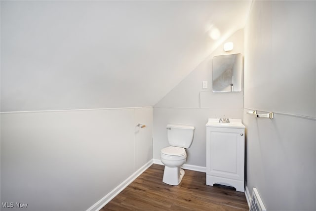 bathroom with vanity, toilet, vaulted ceiling, and hardwood / wood-style floors