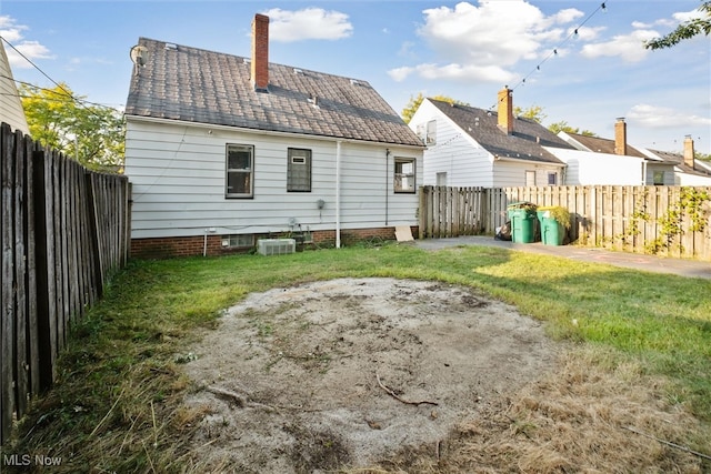 rear view of house featuring a patio and a lawn