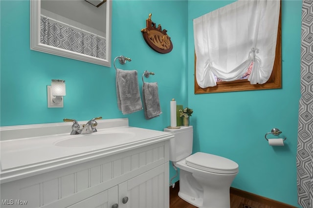 bathroom featuring vanity, toilet, and hardwood / wood-style floors